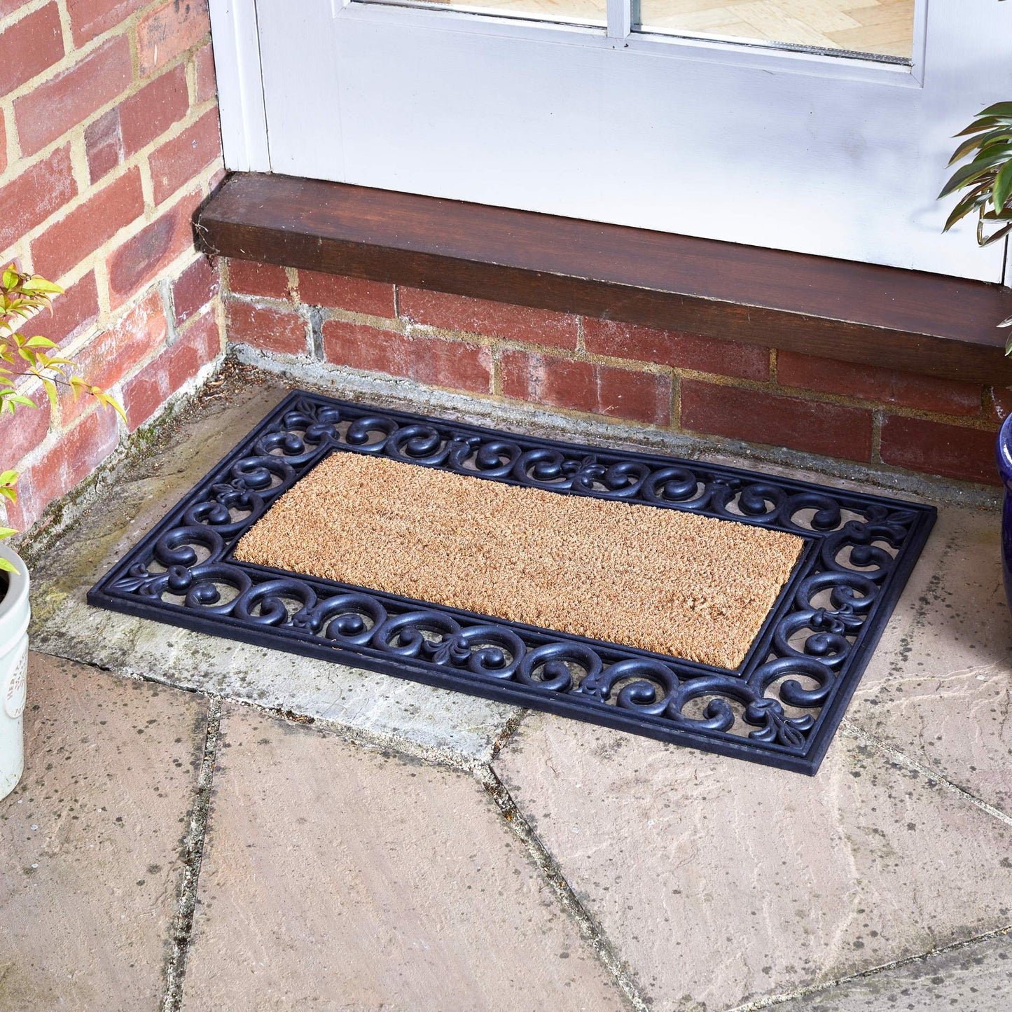 Kompletna rohožka Mix-n-Mats Original skladajúca sa z gumového rámu a vnútornej vložky z kokosového vlákna pred vchodými dverami do domu. Od Outside In designs