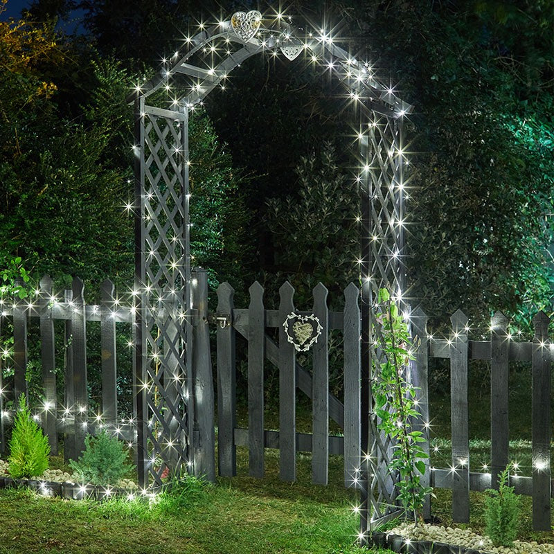 LED reťazové svetlá osvetlujúce drevený plot v záhrade