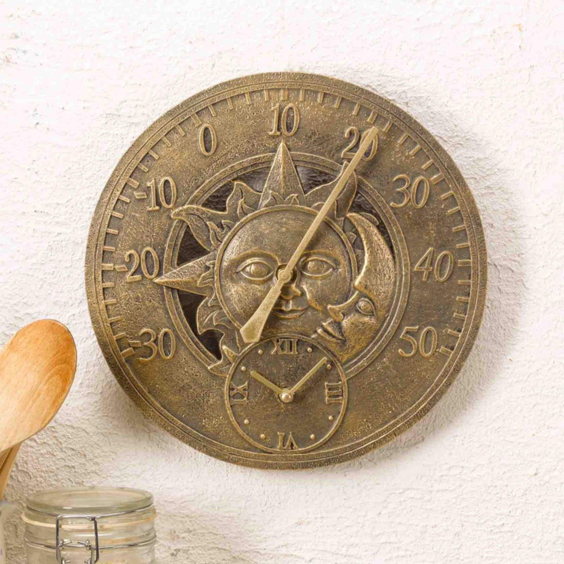 Nástenný teplomer s hodinami s priemerom 30cm ozdobené slnkom a mesiacom na chalupe v kuchyni