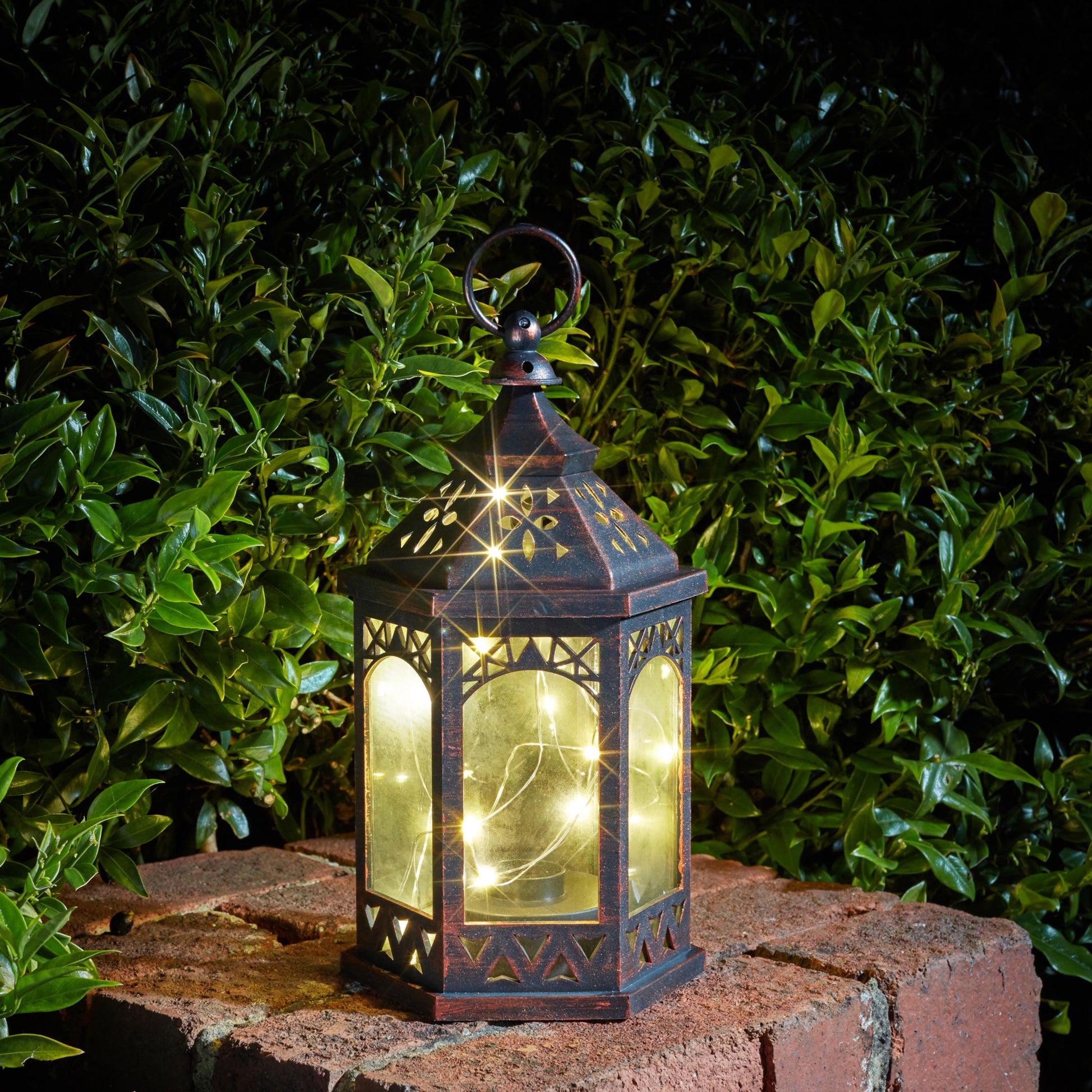 Menší marocký lampáš s 20 teplými bielymi LEDkami na tenkom drôtiku vytvára svetluškine svetlo v záhrade