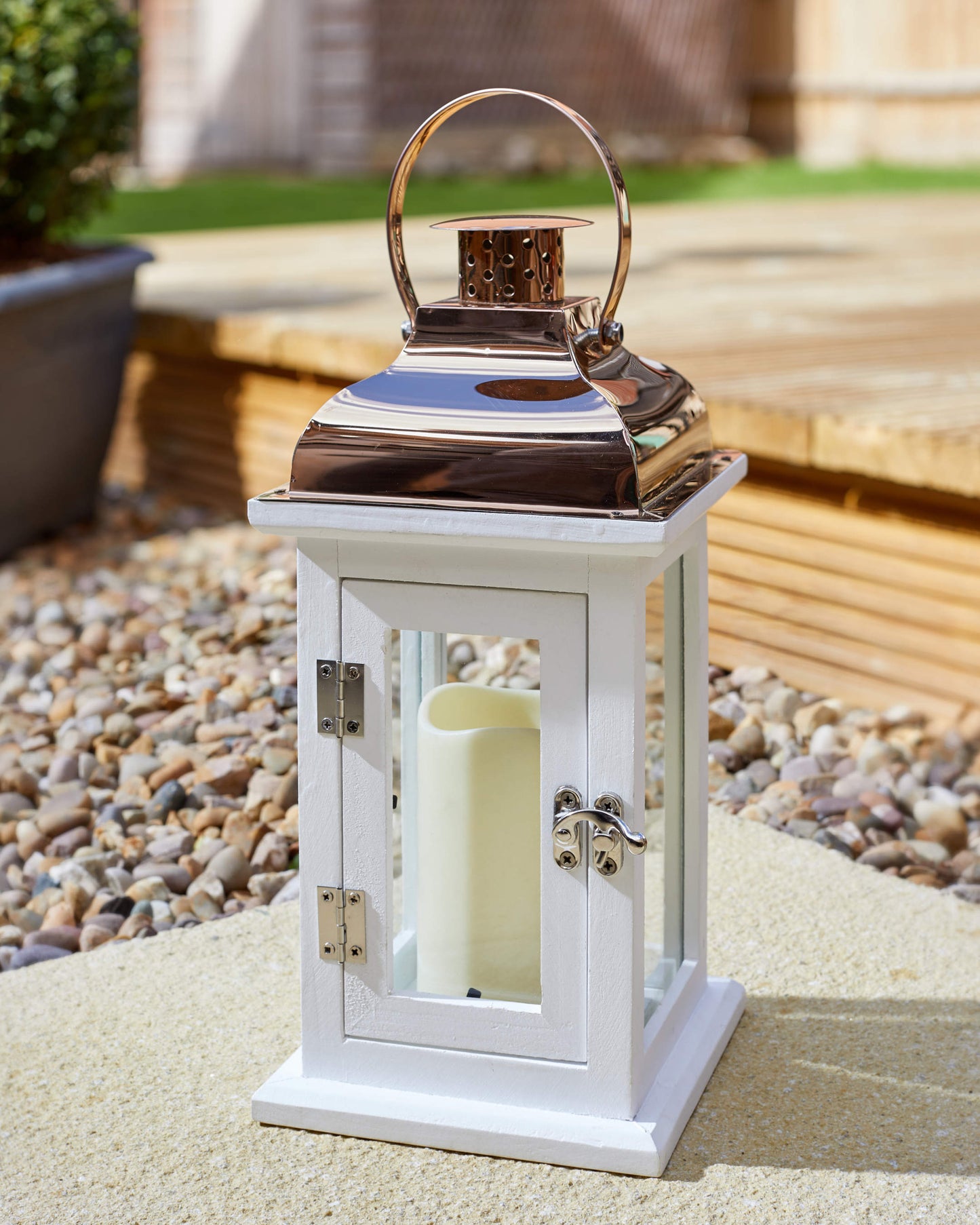 Klasický drevený lampáš Hagen v bielej farbe s kovovou strieškou s vloženou LED valcovou sviečkou je aj cez deň krásnou dekoráciou na terase